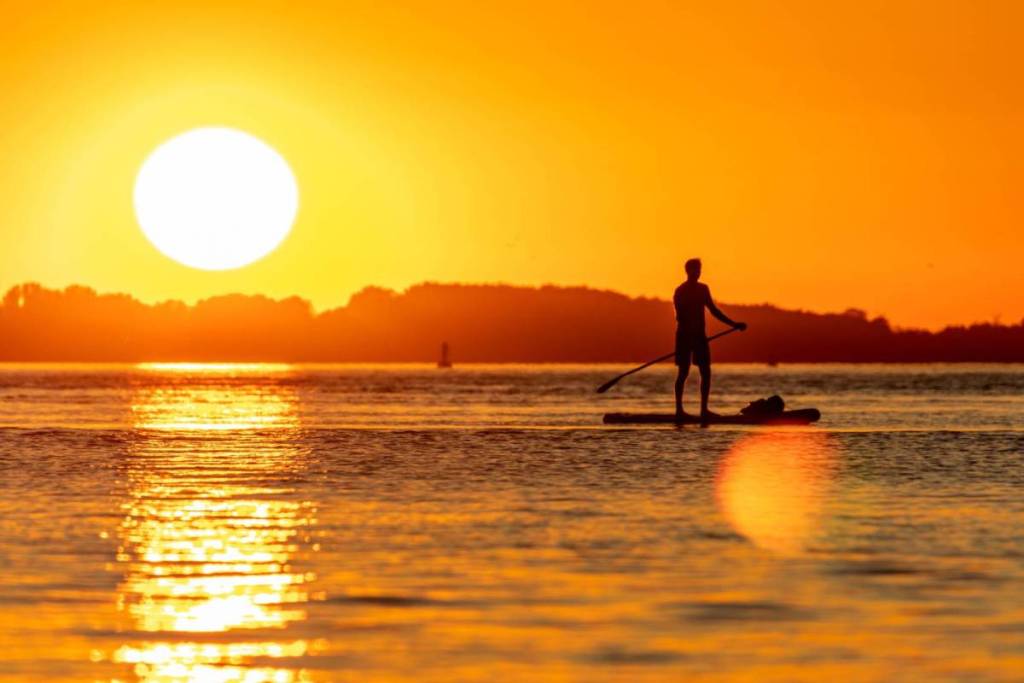 Stand-up paddleboarding at sunset