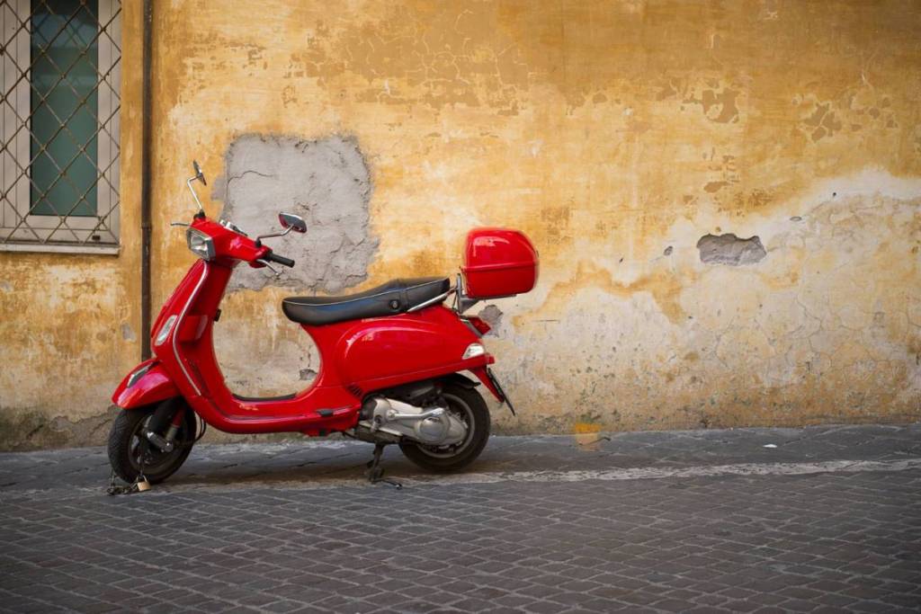 Bild einer roten Vespa vor einer Hauswand