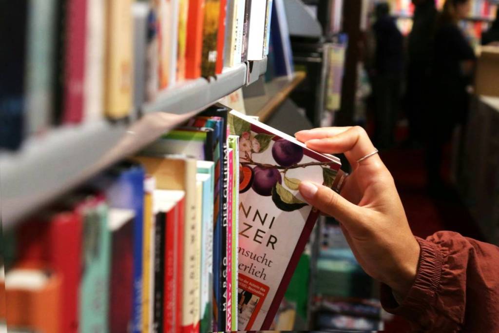 hand zieht buch aus einem regal