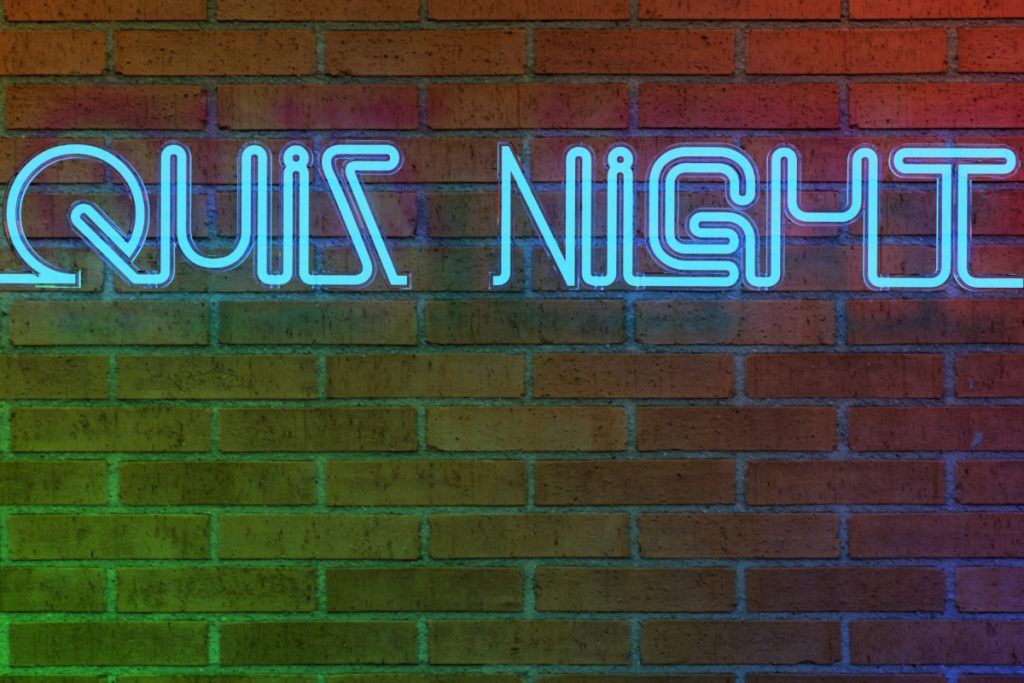 Neon-Schild mit dem Schriftzug Quiz Night vor einer Backsteinwand