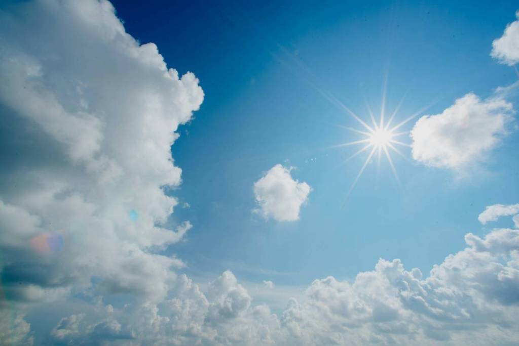 sonne und quellwolken am blauen himmel