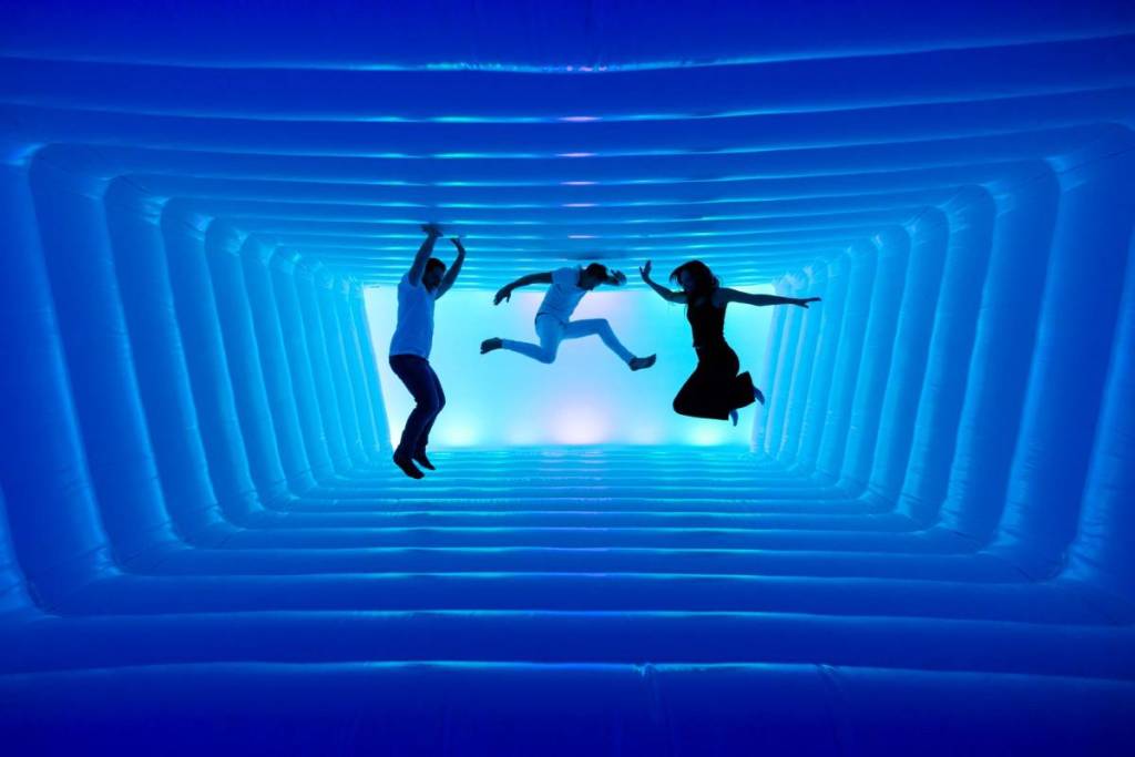 Drei Personen springen in einer traumähnlichen Hüpfburg bei "Dream Rooms"