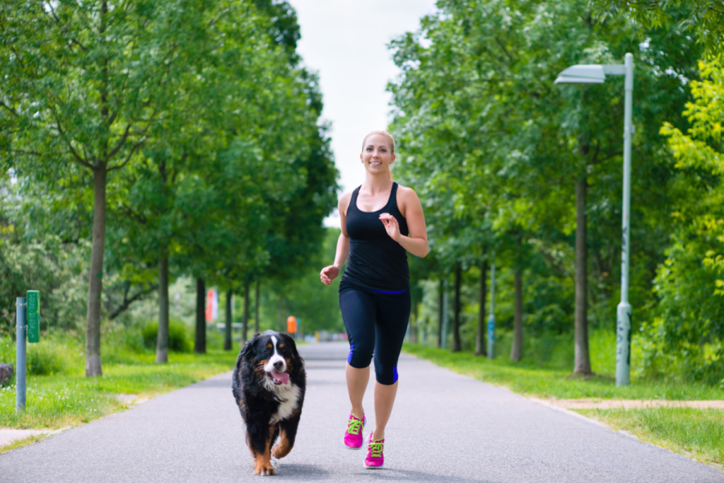 Frau joggt mit Hund im Park