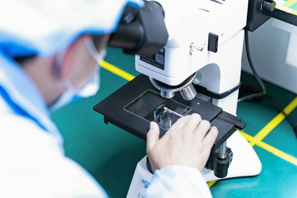 person at a microscope