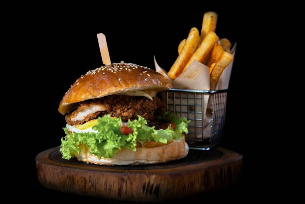 burgers with fries on a wooden board