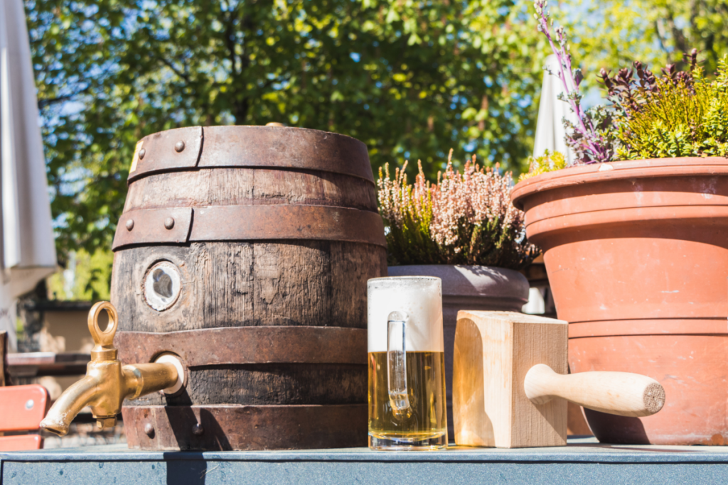 Bierfass, Holzhammer und Bierglas in einem Biergarten in Bayern