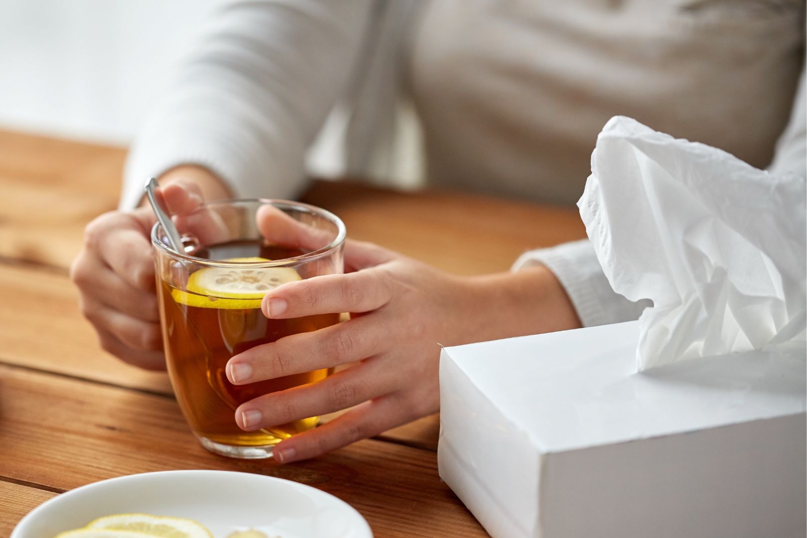 person drinking lemon tea with a tissue box