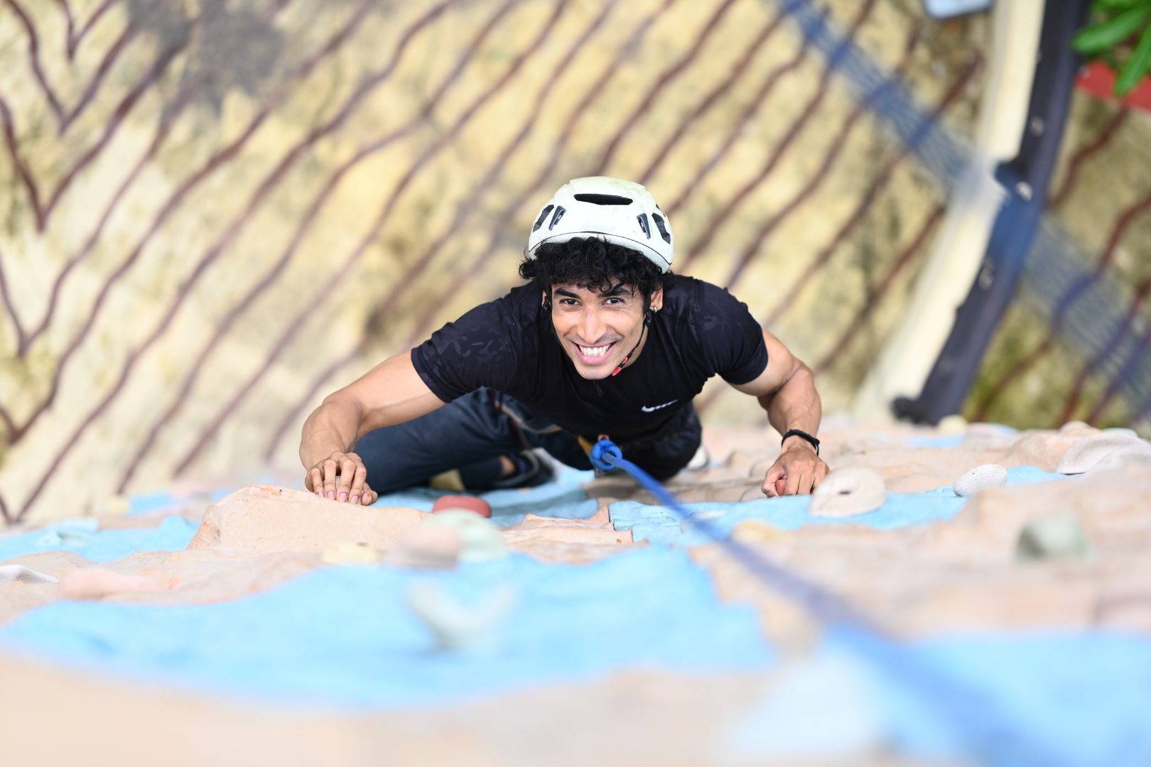 A man scaling a rock climbing wall at Diamond Parks Adventure Zone