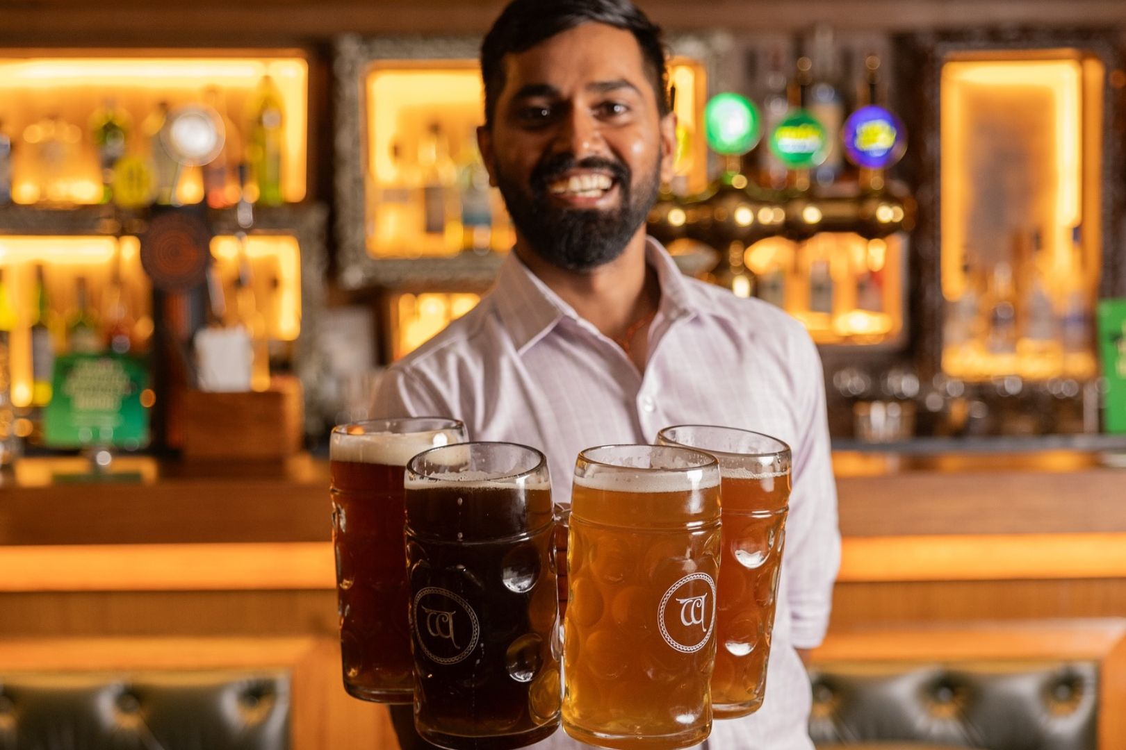 Woodside Inn Oktoberfest staff holding many steins of beer against bakcdrop of bar area