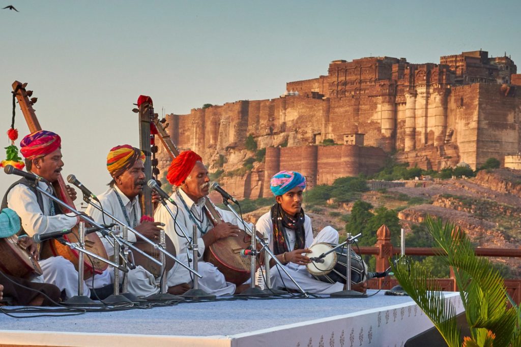 A group of performers playing in front of a mountainous backdrop at the Sacred Spirit Festival