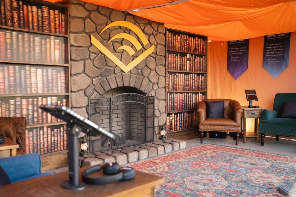 the audible listening tent available to visit at DroneArt Show Nashville, a cosy tent space with mock fireplace and bookshelves and armchairs