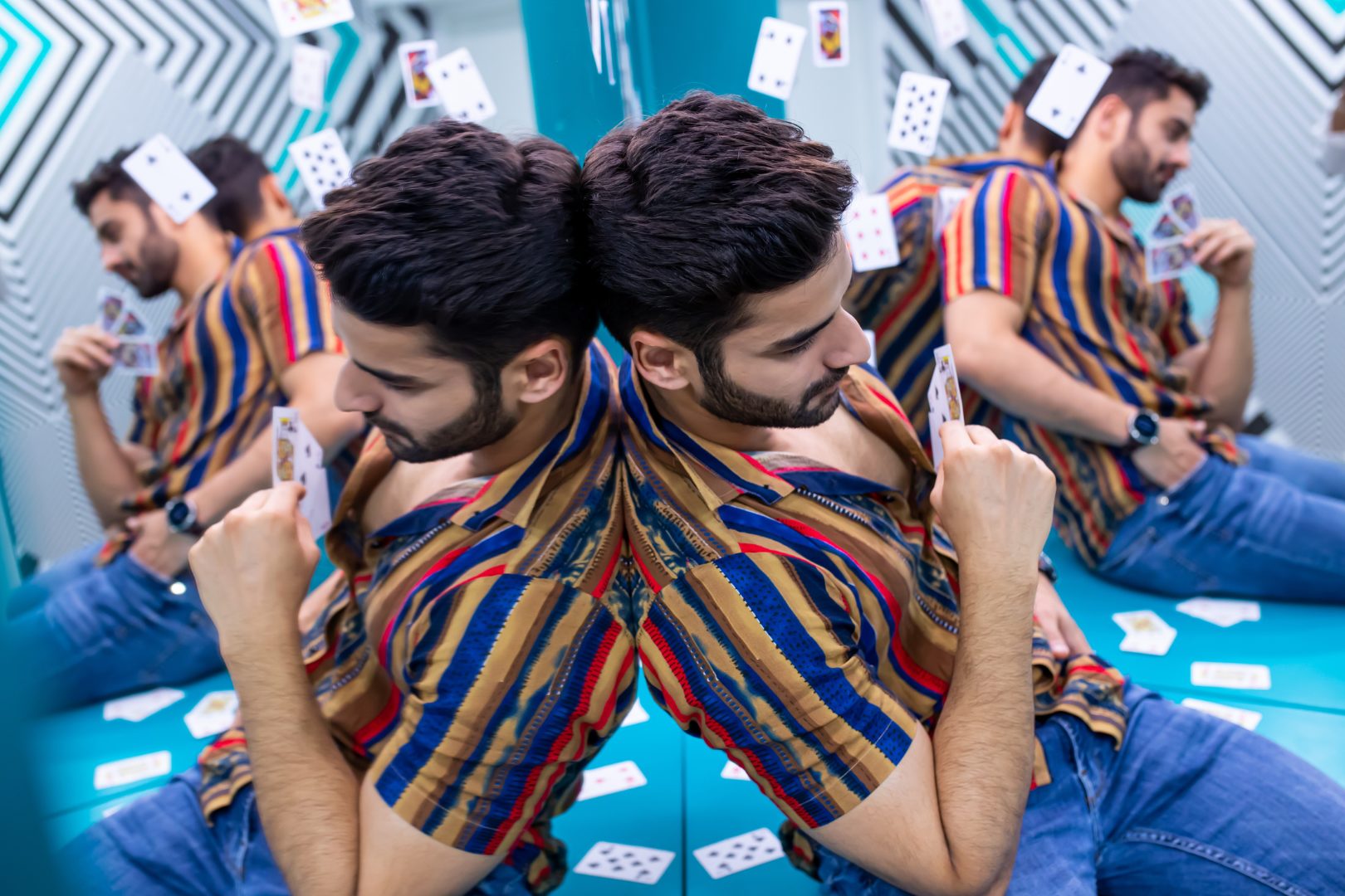 A man sat against a mirror creating the illusion of him all around the room at the Museum of Illusions in New Delhi