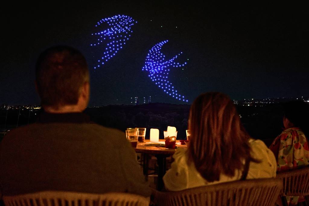Illuminated drones fly over a string quartet