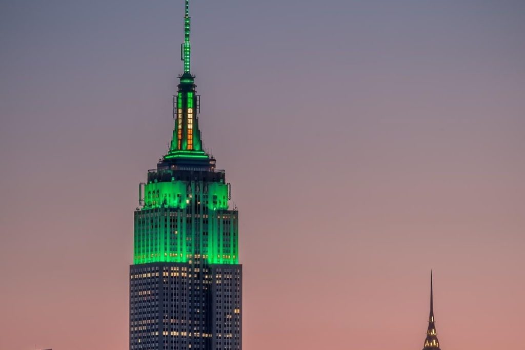 L'Empire State Building illuminé en vert avec un drapeau irlandais au mât pour la Saint-Patrick