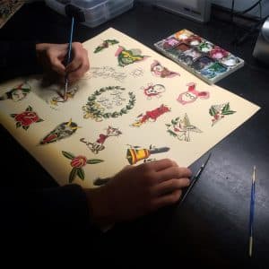 Person drawing tattoo concepts at Electric Anvil Tattoo NYC