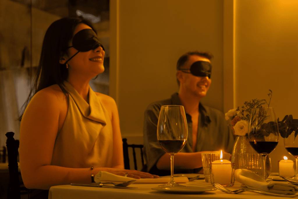 Blindfolded couple at a Dining in the Dark event
