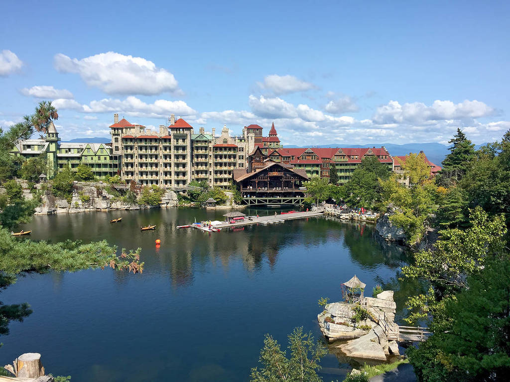 Mohonk Mountain House across a lake with a dock and small rock island in New Paltz, New York
