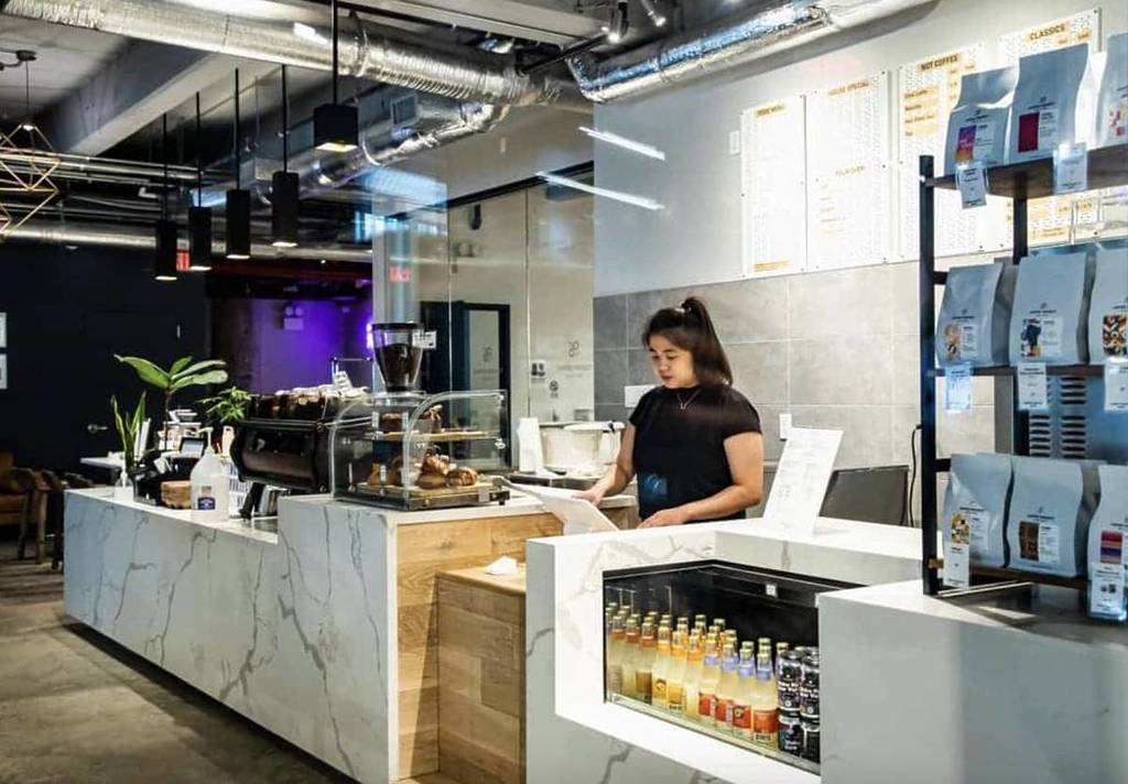 Un barista debout derrière le comptoir de l’Academy at Coffee Project NY à Long Island City