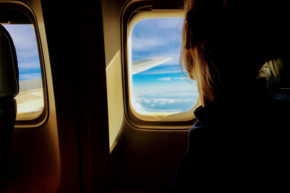 A woman looking out an airplane window