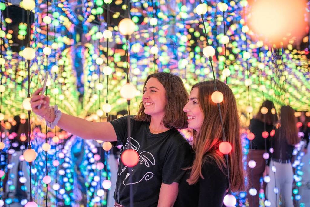 visitantes tirando selfies entre as luzes infinitas na Dopamine Land