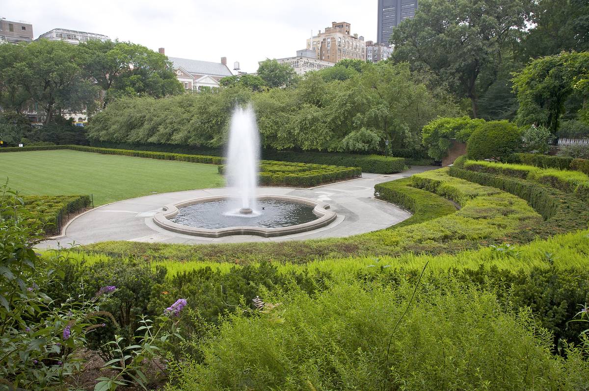 Conservatory Garden, Central Park's six acre formal garden, New York, N.Y., U.S.A. Central garden, designed by Gilmore D. Clarke, lansdscape architect, 1937. Symmetrical lawn, clipped yew and single central fountain jet.