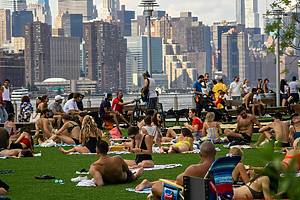 People crowd Domino Park in the Williamsburg neighborhood in Brooklyn in New York to bake in the sun