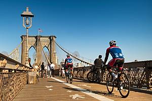Manhattan, New York - September 22, 2019: A man cycles on the bike path on the Brooklyn Bridge over the East River during the morning sunrise connecting Manhattan New York to Brooklyn USA