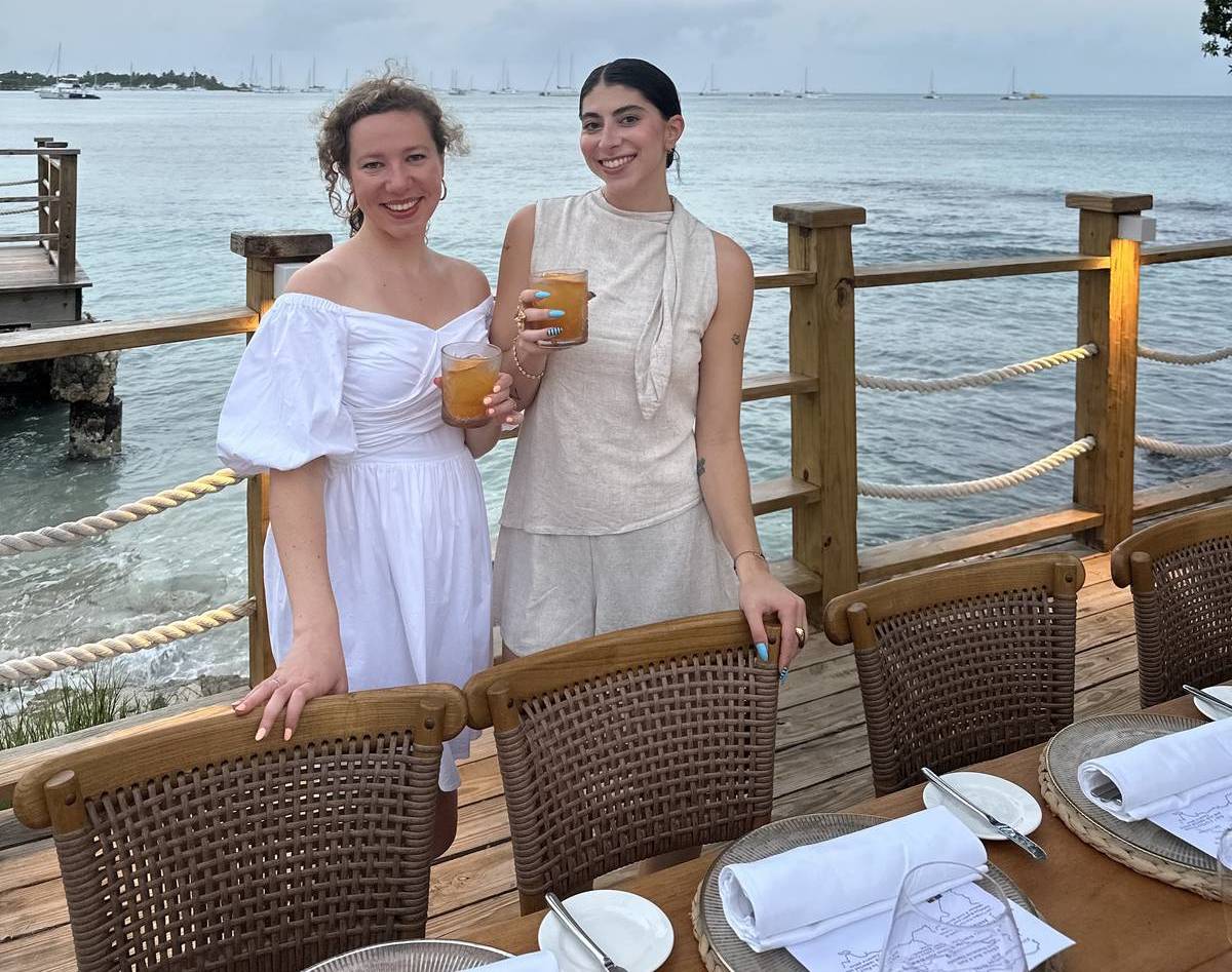 Two women standing on a pier behind a dinner table