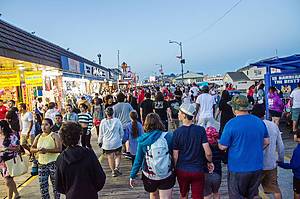 Crowd walking on Wildwood boardwalk at night