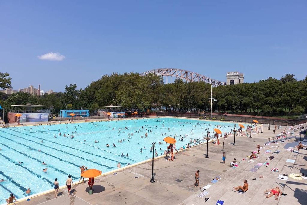 Astoria Queens, New York / USA - 25 agosto 2020: Piscina di Astoria presso l'Astoria Park durante l'estate con persone e il ponte Hell Gate sullo sfondo
