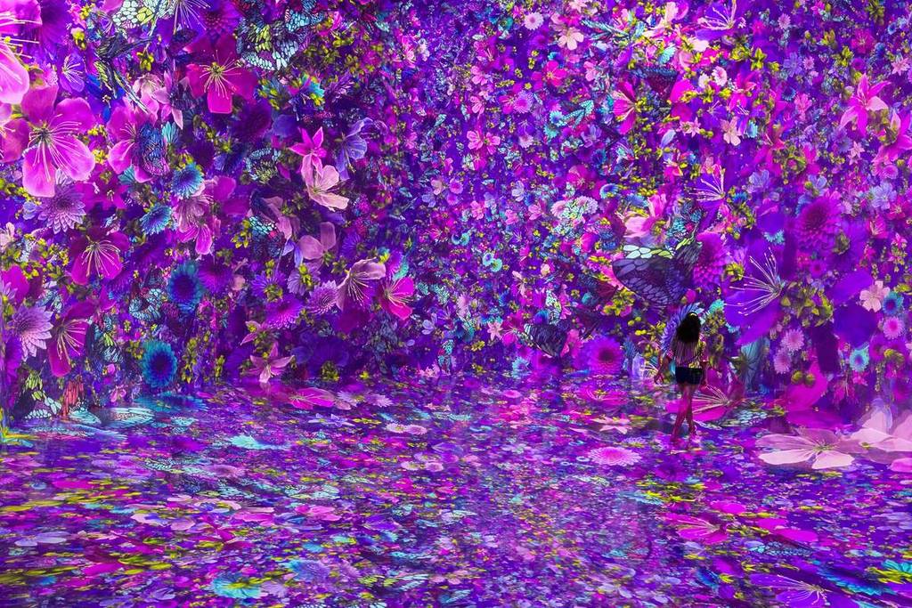 Guests at Blooming Wonders exhibition surrounding by a digital landscape of blooming flowers