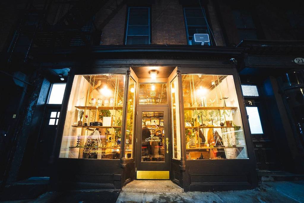 Art of Play Curiosity Shop exterior at night