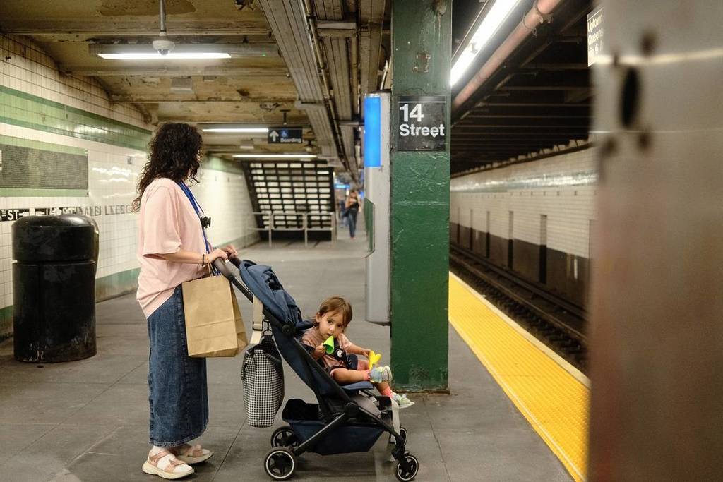 Mother with her child in a stroller waiting for the subway