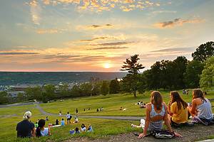 Ithaca New York - June 26, 2021: Students at Libe Slope watching sunset on campus of Cornell University.  Cornell University is a private, statutory, Ivy League and land-grant research university