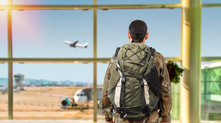 Military member standing in front of airport window