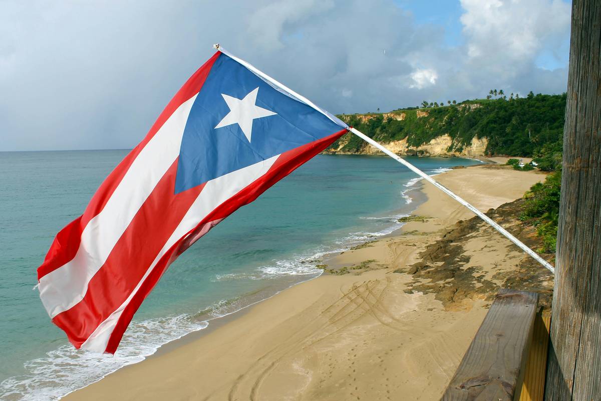 PR flag over a beach