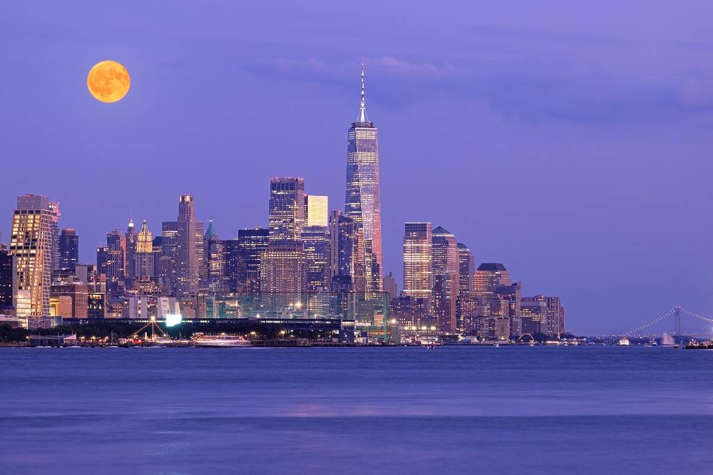Full moon with an orange hue of NYC skyline