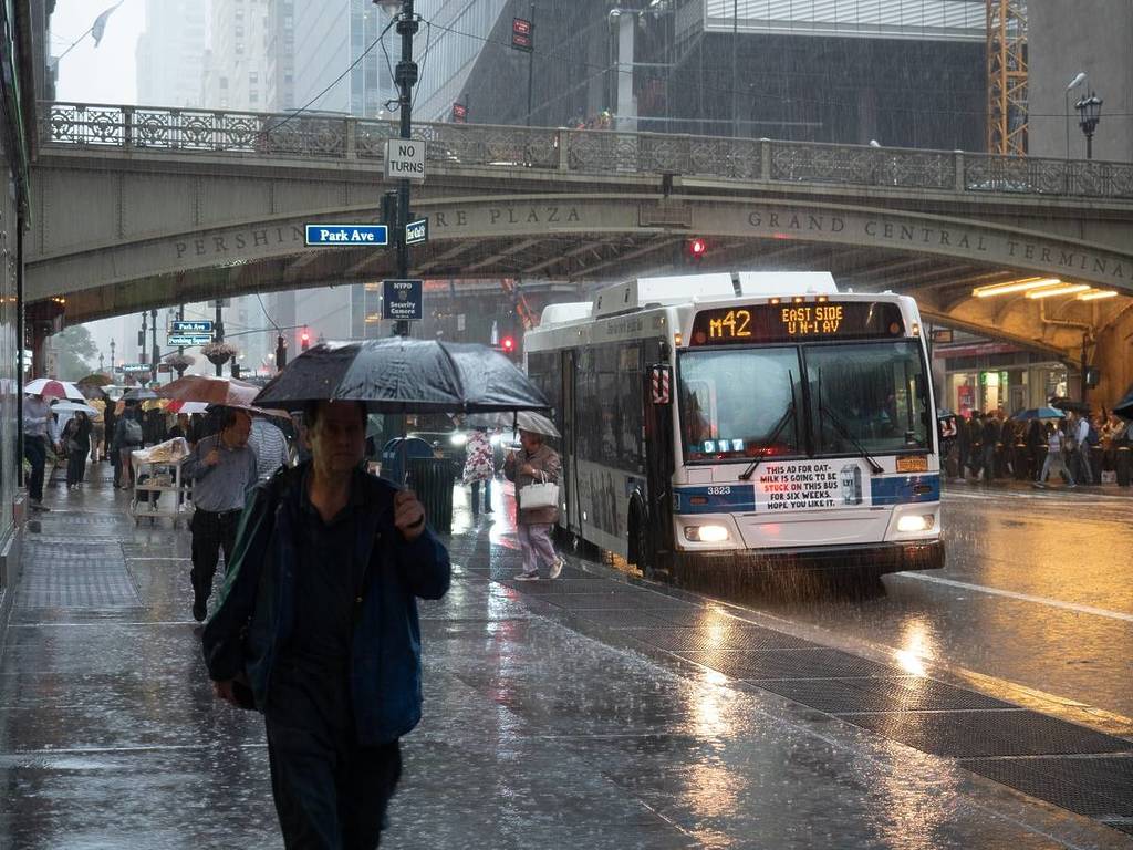 Mensen lopen met paraplu's in een stortbui in NYC