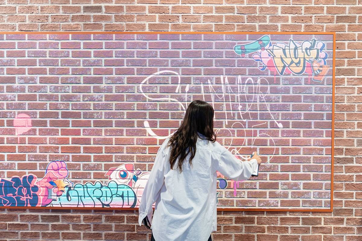 A person is using the digital graffiti wall at the Galaxy Experience Space