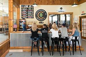 People at Cooperstown Brewing Company sitting at a bar drinking beers and chatting.