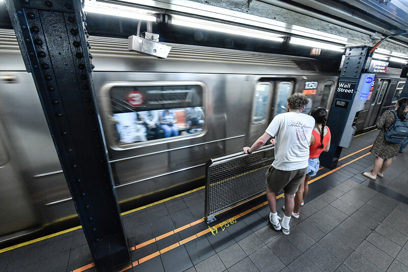 Riders standing at subway edge platform