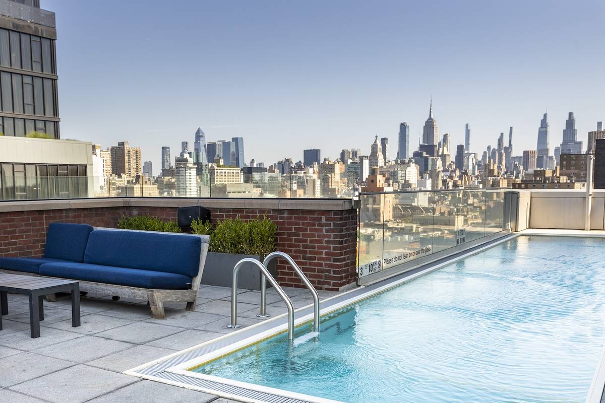 The NYC skyline behind a rooftop pool at Mr Purple