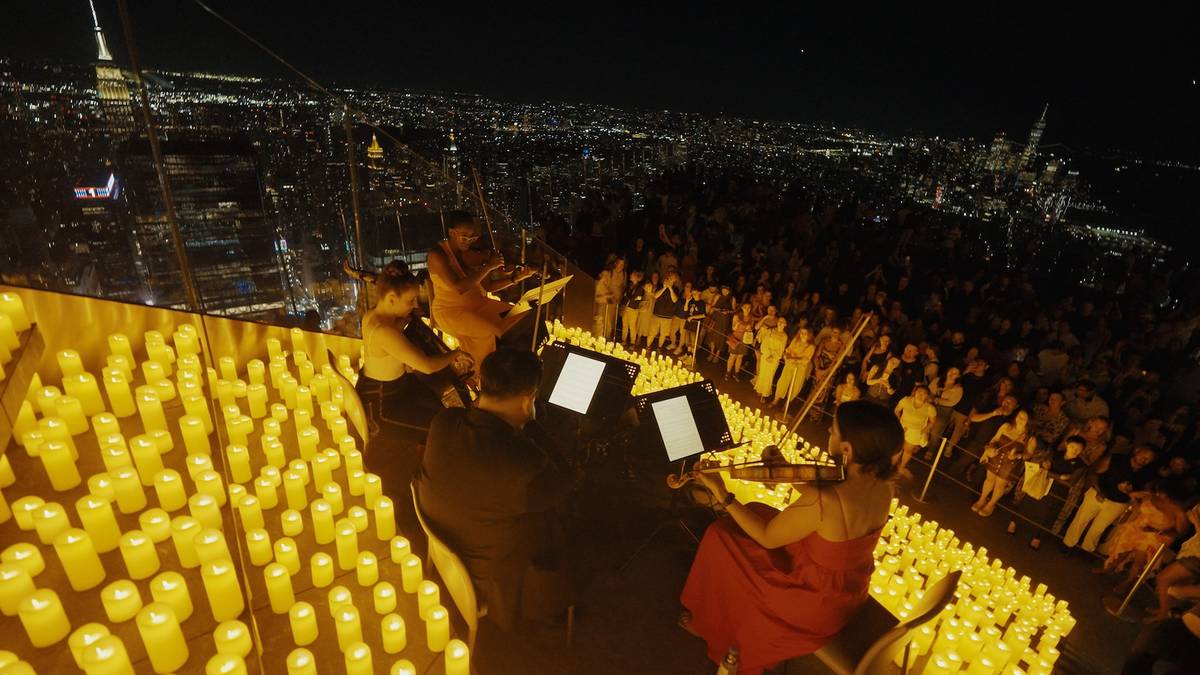 A view from Edge NYC with a string quartet playing to a crowd surrounded by 1000s of candles.
