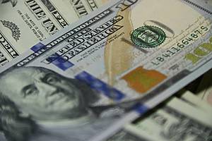 US hundred dollar bill on top of other cash bills