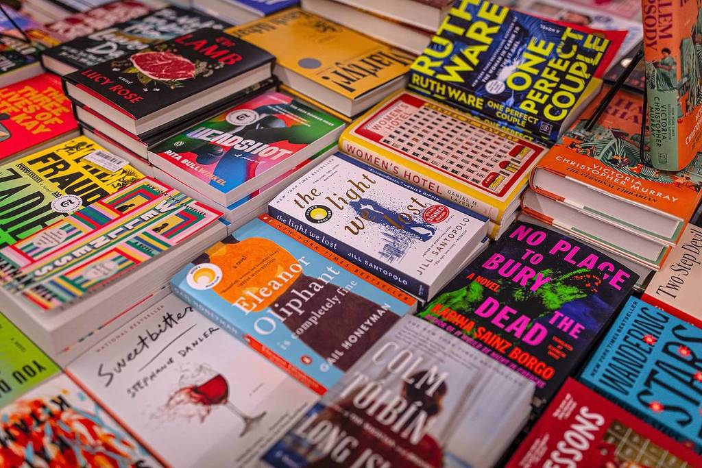 New York City, NY US - April 16, 2025: stacks of books displayed on a table or a shelf in a bookstore. Top view of a book display at a bookstore. Books for sale in a bookshop.
