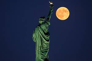 Full moon illuminated over the Statue of Liberty