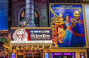 Billboards for Disney's Broadway shows The Lion King and Aladdin, featuring vibrant signage in Times Square