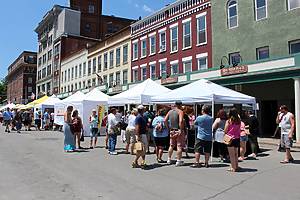 Little Falls, New York - July, 2019: People gathered under vendors tents, where a variety of fresh cheese and other goods are for sale during the annual cheese festival.