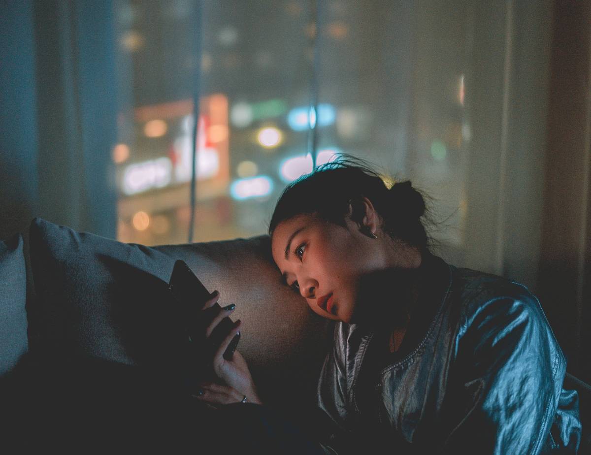 Woman sitting on a couch looking at her phone