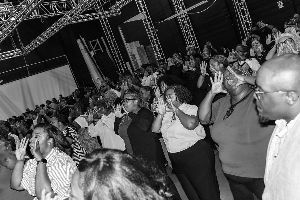 voices of fire choir members in rehearsals, black and white image, hands to their mouth in shouting action